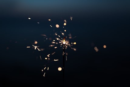 A quick burst of light coming from an electrical outlet from a household appliance. 