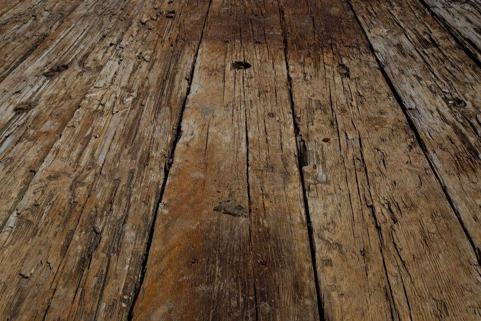 Wooden floor in a home that has severe termite damage from an infestation all the floorboards. 
