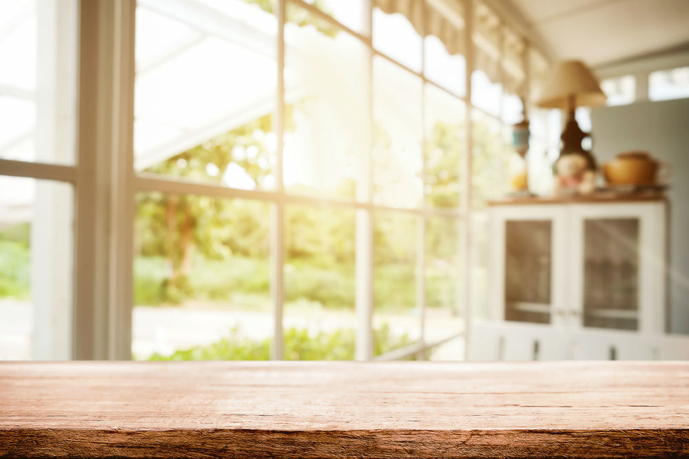 Table in a suburban home with a background window reflecting natural light through it.