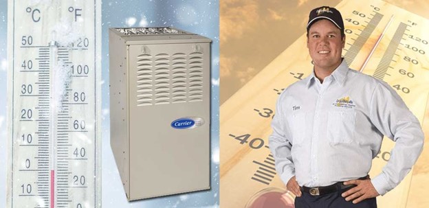 Cropp Metcalfe technician standing next to a furnace and thermometer in the winter. 