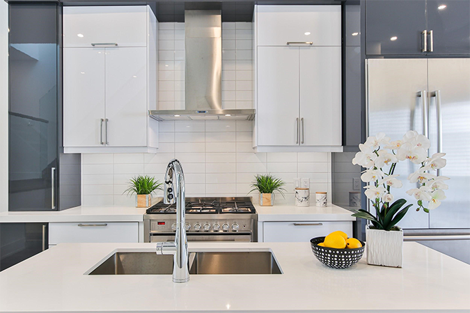 Kitchen with white marble and countertops in a suburban home with a kitchen sink centered. 