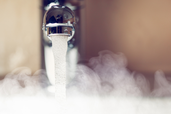 Hot water running out or a bathroom sink with steam coming from the water. 