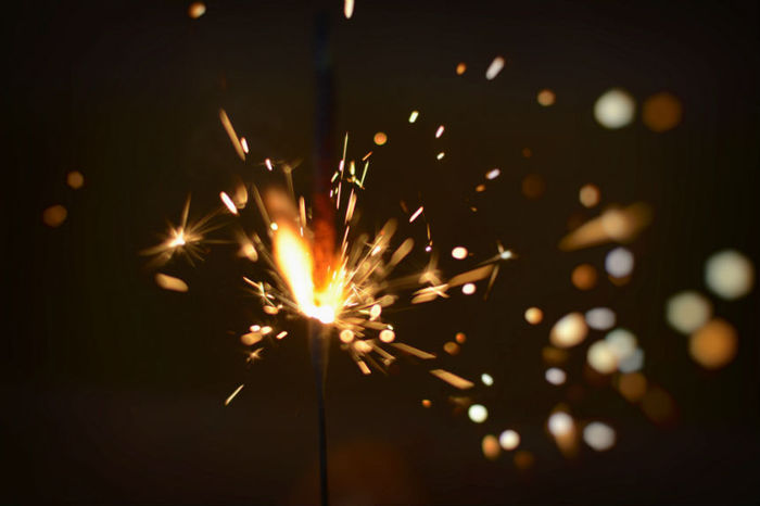 Bright spark stemming from the end of a wire that has sparks coming out from it. 